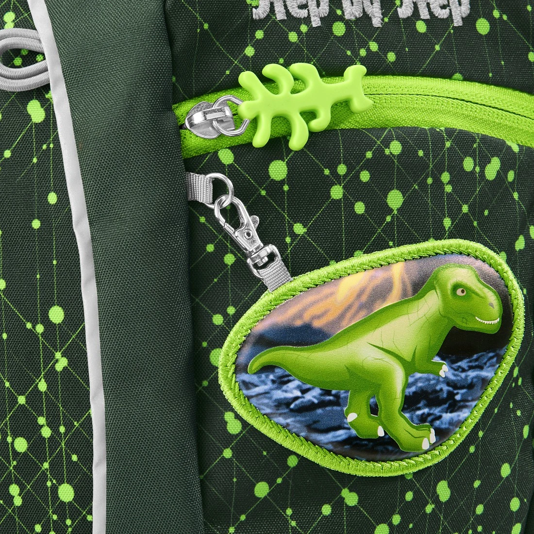 Detail přívěsku KIGA MAGS s dinosaurem na přední kapse